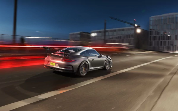 Silver Porsche 911 GT3 RS speeds through a city street at night with motion blur effects, captured in a crisp 4K Ultra HD desktop wallpaper.