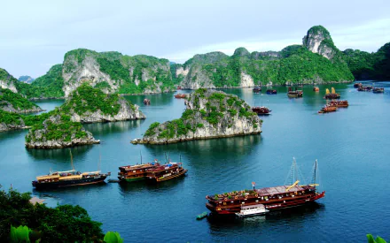 HD desktop wallpaper showcasing boats sailing among the lush limestone islands of Ha Long Bay under a clear sky.