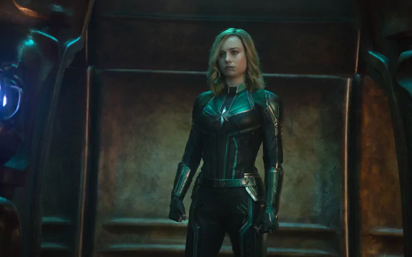 Brie Larson as Captain Marvel in a striking 4K Ultra HD movie scene, featuring her in a dark, armored suit against a metallic backdrop.
