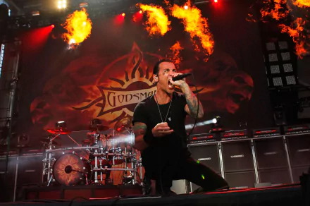 HD wallpaper of a Godsmack concert with lead singer performing and flames in the background.