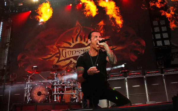 HD wallpaper of a Godsmack concert with lead singer performing and flames in the background.