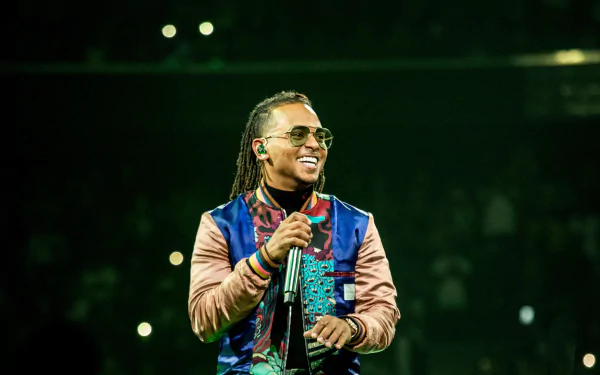 HD desktop wallpaper of a smiling performer on stage, tagged with Ozuna, with a vibrant concert background.